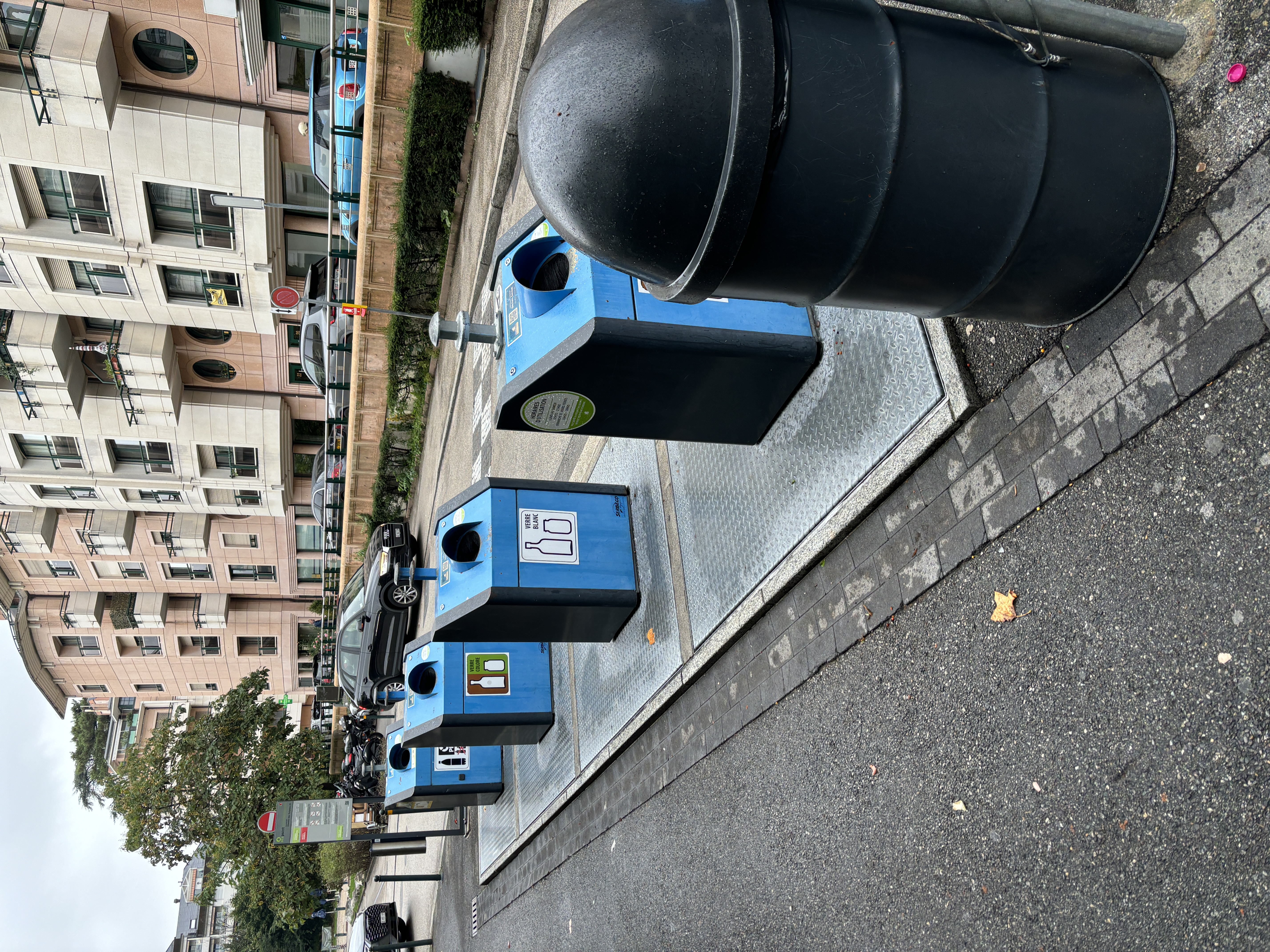 Blue recycling bins outside an apartment building